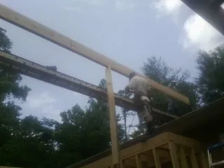 Carpenter setting a ridge beam over a new addition frame — Ice Dam Removal by Roofing Brothers in East Greenville