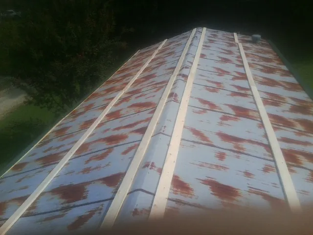 Rusted metal roof panels with new wood purlins before replacement — Storm Damage Roof Repair in East Greenville by Roofing Brothers