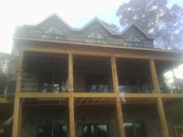 Dormers and porch framing on a large log home under construction — Roof Coating work by our crew in East Greenville