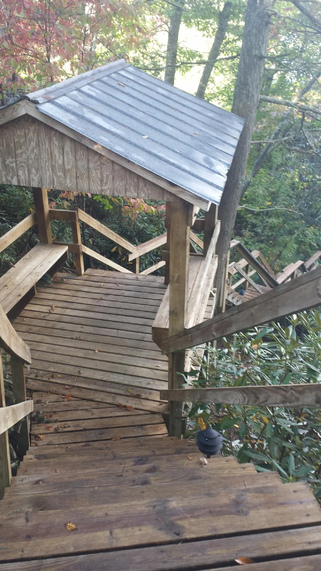 Metal roofed shelter over wooden steps on a wooded walkway — Skylight Repair & Installation work by our crew in East Greenville