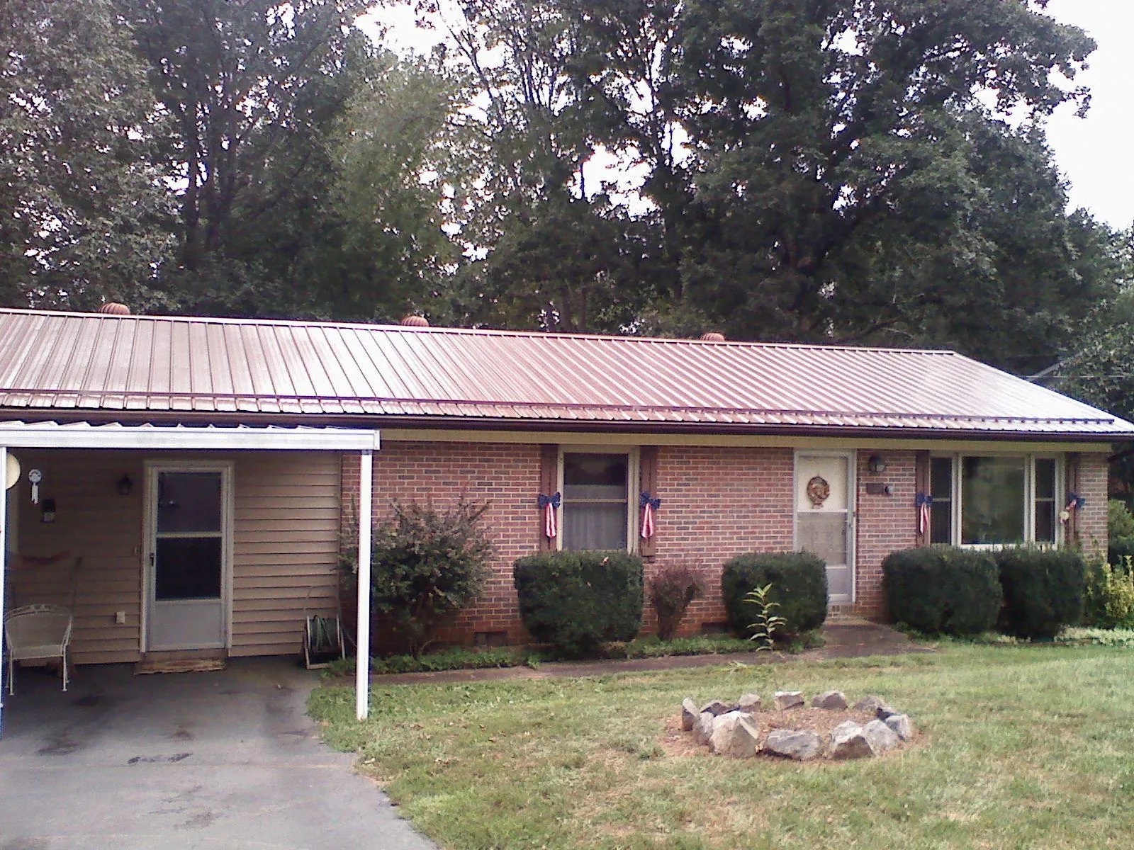 Bronze metal roof and carport on a brick ranch home — Roof Repair work by our crew in East Greenville